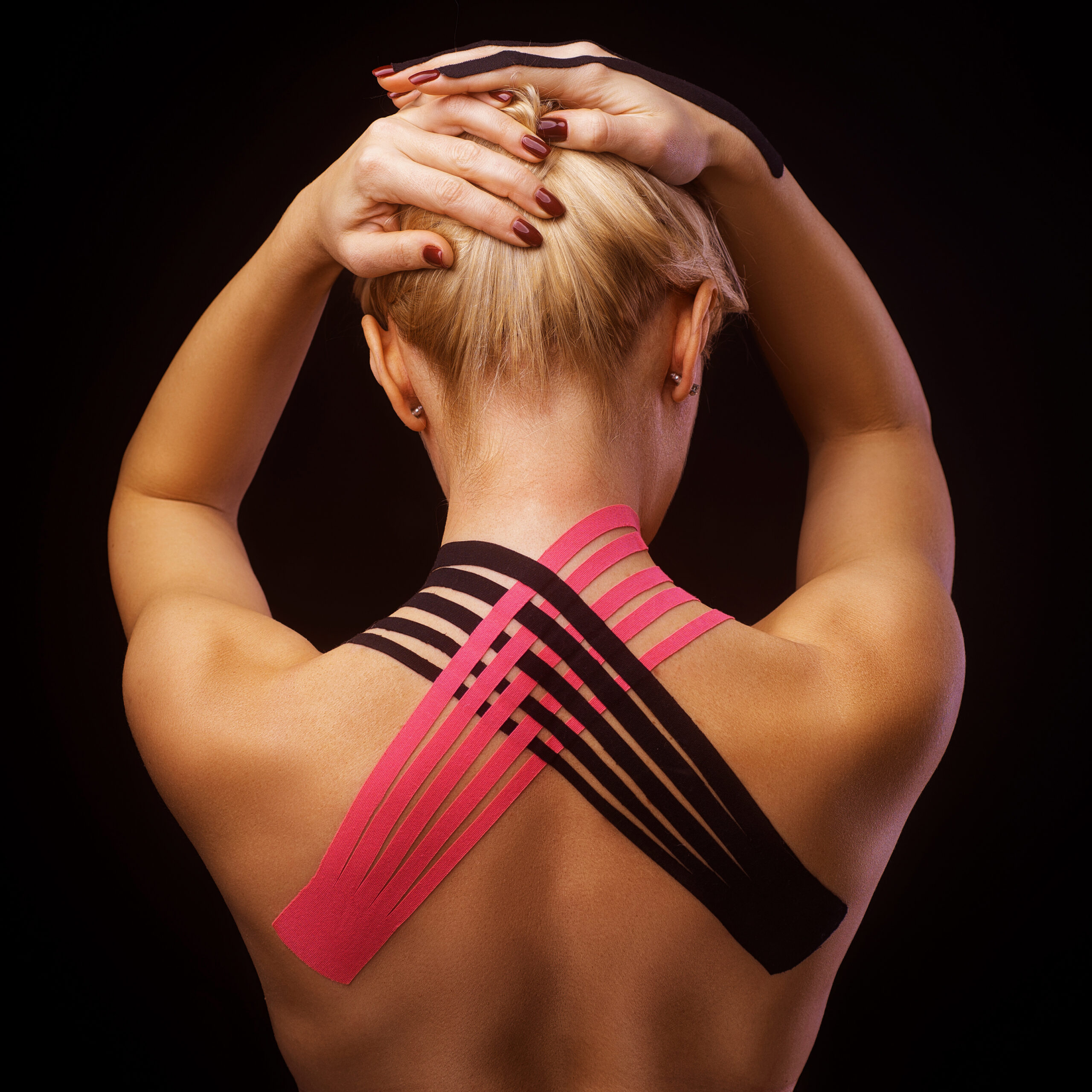 Beautiful young woman with kinesiotape on her neck area after injury on black background